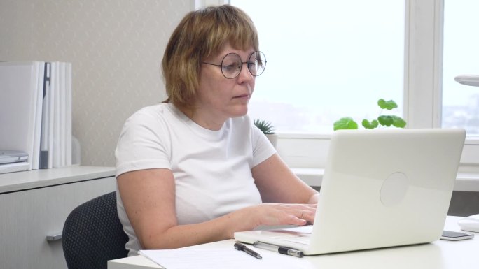 高效率的工作空间:在家办公室用电脑打字的女人