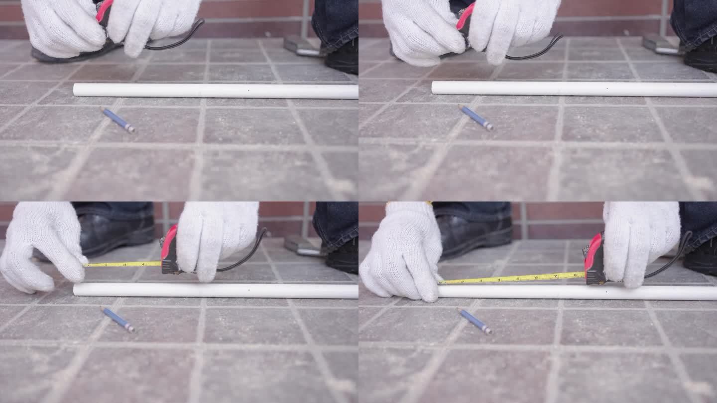 近照，男电工的手正在用卷尺测量白色塑料管的长度。