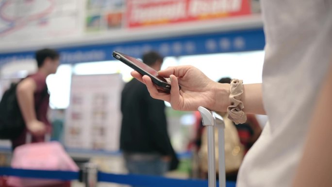 一名女商人在日本京都火车站用智能手机在线激活了她的火车票