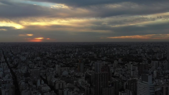 日落时分，无人机在布宜诺斯艾利斯上空飞行，城市轮廓映衬着渐暗的日光