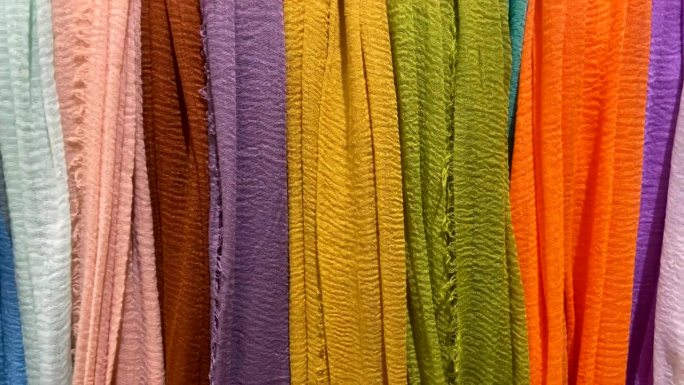 多色织物在纺织商店的特写。购物，工业，销售和服装的概念。街市上五颜六色的纺织品。