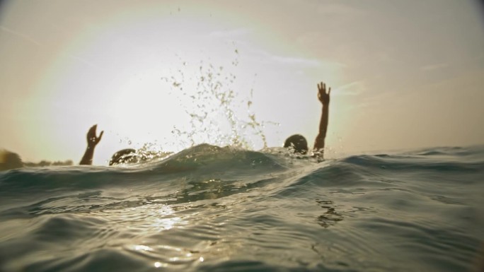水下宁静:一对夫妇用他们的手臂向上伸展，轻轻地打破海面