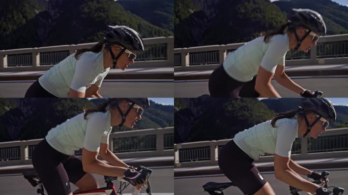 女自行车手在阳光明媚的山路上坡