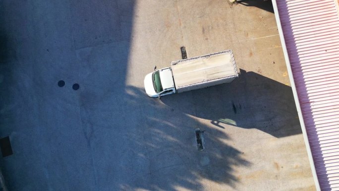 一辆卡车倒车进入仓库码头的鸟瞰图。葡萄牙