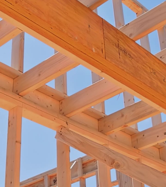 在施工过程中，木结构框架的房屋正在用支撑梁建造