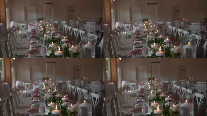 为婚宴精心安排的长桌设置，装饰着精致的蜡烛，鲜花和所有细节，营造出浪漫和时尚的氛围。