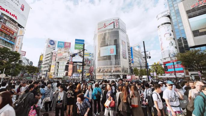 涩谷城市生活的实时剪辑，日本东京的旅游景点地标。日本人山人海，游客走在拥挤的十字广场。汽车交通运输。