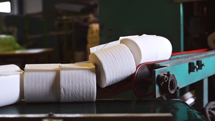 卫生纸卷沿着传送带移动。生产卫生用纸卷的希腊工厂。制造纸巾和卫生纸。