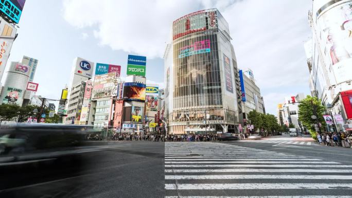 涩谷城市生活的时间流逝，日本东京的旅游景点地标。日本人山人海，游客走在拥挤的十字广场。汽车交通运输。