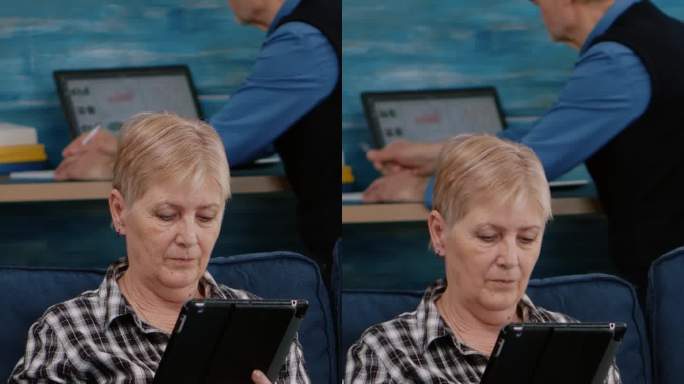 垂直视频:中年老妇人放松地拿着平板电脑看电子书