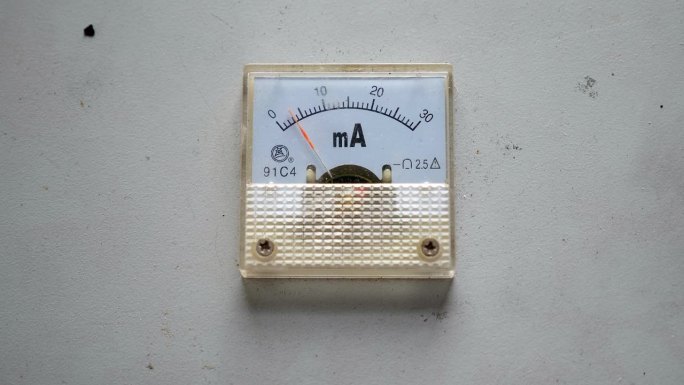 白色墙壁上工厂电压表的特写。工业电压表。