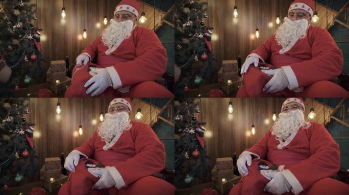圣诞老人坐在圣诞树旁准备礼物袋