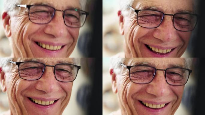 一个快乐的老人的特写镜头，他戴着眼镜笑着，和蔼可亲