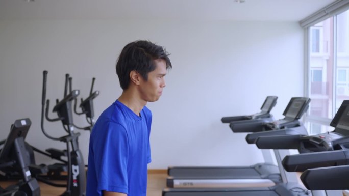 亚洲年轻的截肢者没有手臂在跑步机上跑步健身。有吸引力的快乐的残疾运动员，运动员锻炼和锻炼，以保持肌肉