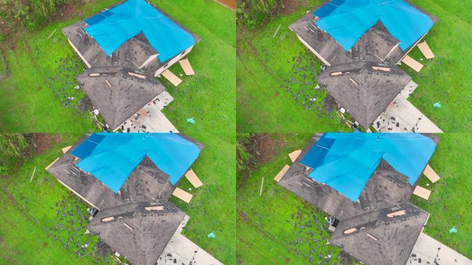 鸟瞰图，飓风伊恩损坏的屋顶覆盖着蓝色防水布防止雨水泄漏，直到更换沥青瓦