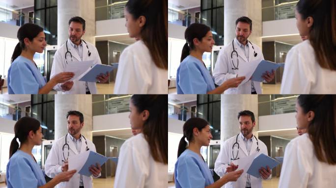 在医院与团队的简短会议中，男医生将表格递给一名医学实习生