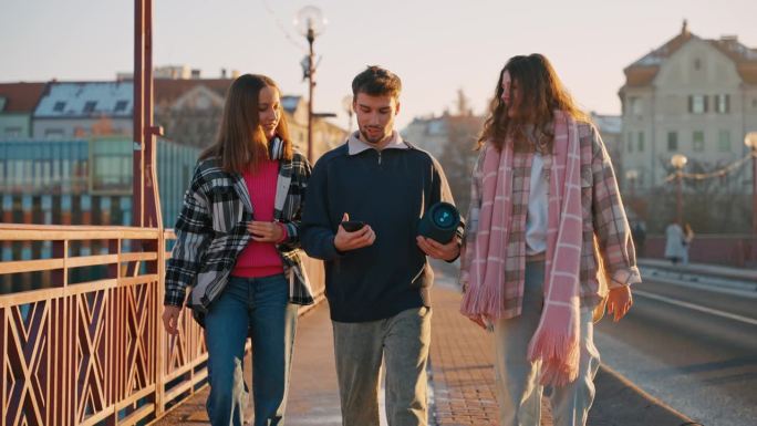 SLO MO年轻男舞者与女性朋友在城市人行道上散步时将无线扬声器连接到智能手机