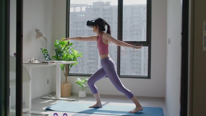 亚洲女性戴着VR头盔练习瑜伽
