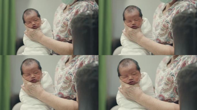 亚洲祖母在家里用爱拥抱刚出生的孙子——亲密的家庭关系和代际联系。