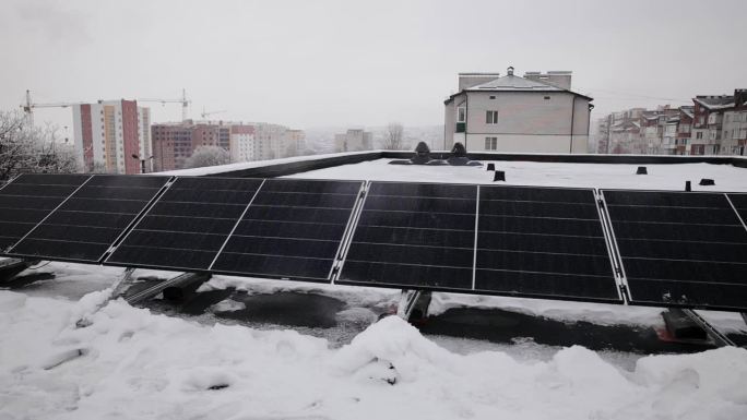 在冬季，建筑的屋顶上安装了几块太阳能电池板。可再生能源生产概念