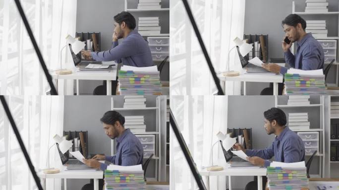 后视图，年轻的男性工人坐在台式电脑前审阅电子销售统计文件