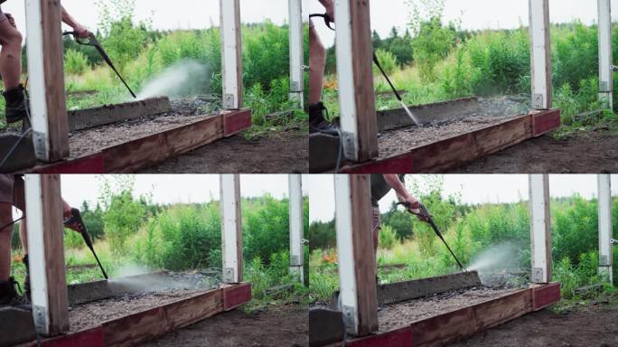 一名男子使用高压喷射水管的裁剪视图。特写镜头