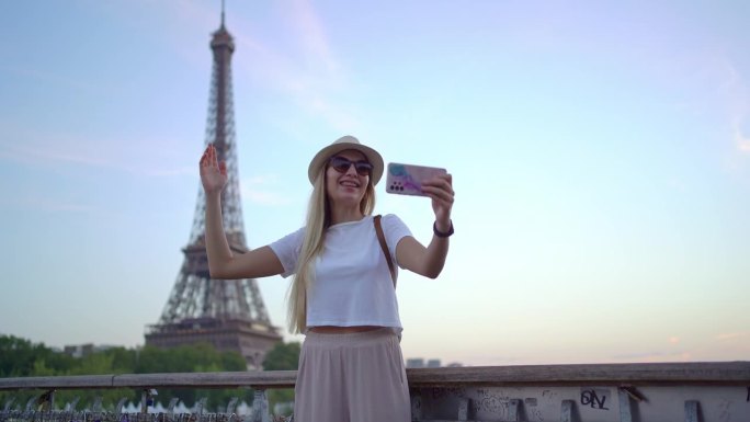 一个快乐的女人在巴黎埃菲尔铁塔前进行视频通话