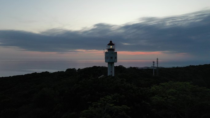 航拍夕阳下涠洲岛南湾鳄鱼山景区灯塔