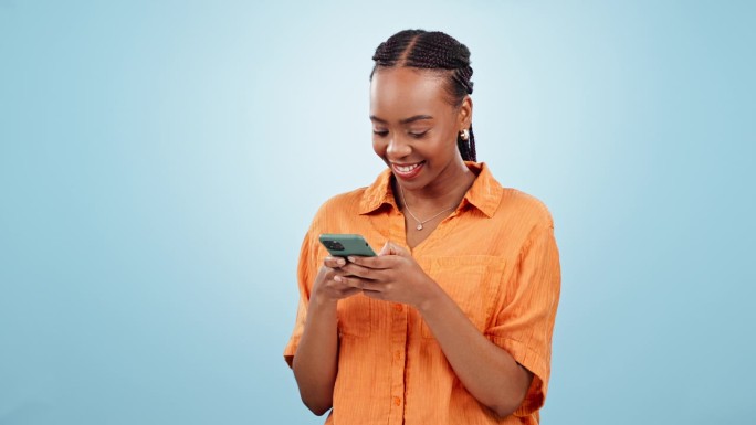 女人，在演播室里笑着用手机打字，更新社交媒体帖子，阅读有趣的通知，在蓝色背景下聊天。快乐的非洲模型下