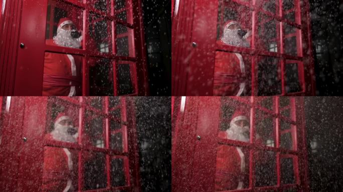 圣诞老人在一个红色的电话亭里打电话，笑着
