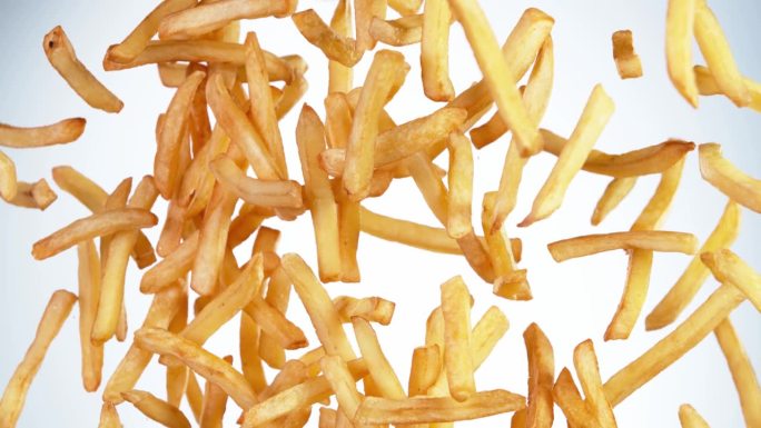 白色背景下飞行薯条的超级慢动作。