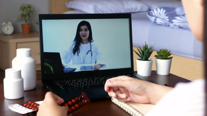 患者利用远程视频会议，通过视频通话在笔记本电脑应用上在线咨询医生病情、用药情况。远程医疗、远程医疗和