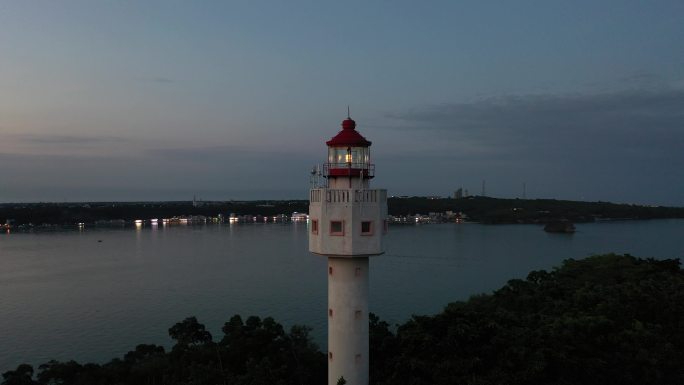 航拍夕阳下涠洲岛南湾鳄鱼山景区灯塔