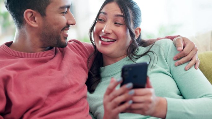 情侣们，在家里用手机笑着聊天，发社交媒体帖子，表情包或下载移动应用程序。快乐的男人，女人，在互联网上