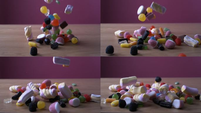 五彩缤纷的糖果分类落在超级慢动作与高速相机拍摄的桌子上，棉花糖，甜的糖果