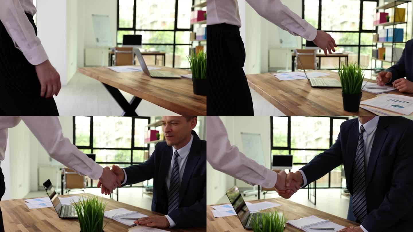 男女在办公室开会时握手