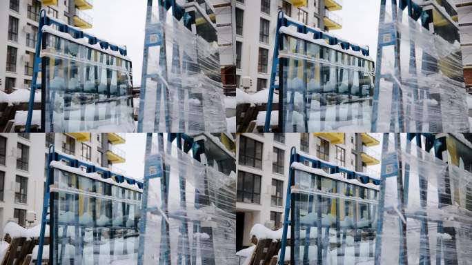 在建住宅楼。一个未安装的双层玻璃窗在冬季被包装并包裹在室外的薄膜中