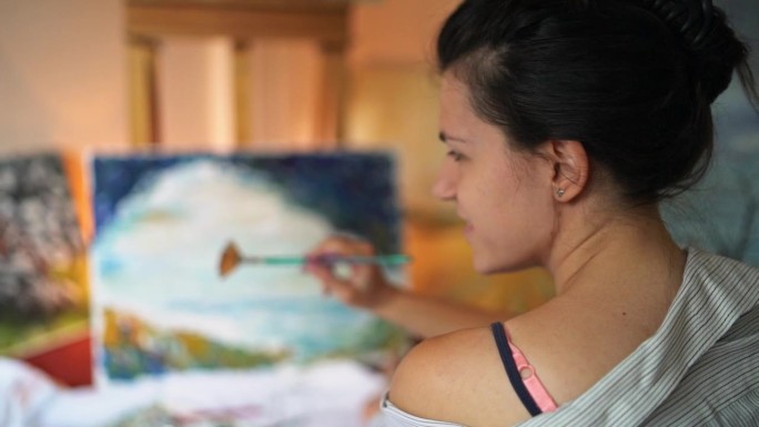 年轻女艺术家在她的艺术工作室绘画