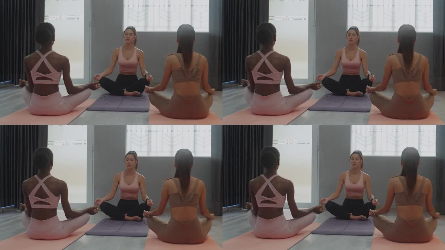 瑜伽教练在瑜伽课上和女性做体式