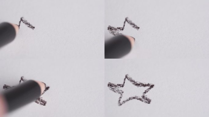 手在白纸上画了一颗星星。一支铅笔画了一颗星星