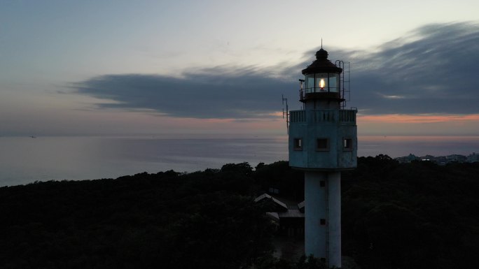 航拍夕阳下涠洲岛南湾鳄鱼山景区灯塔