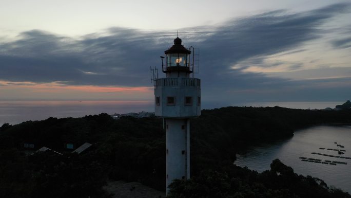 航拍夕阳下涠洲岛南湾鳄鱼山景区灯塔