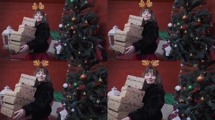 可爱的小女孩抱着新年礼物快乐地站在圣诞树旁
