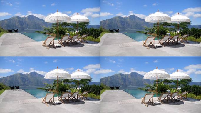 太阳躺椅由豪华酒店外游泳池与惊人的山景。热天的电影视频，泳池边的太阳躺椅，酒店游客的太阳伞。在躺椅和