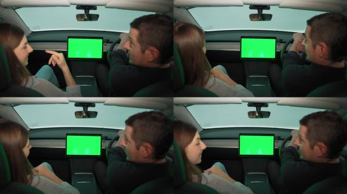 有环保意识的夫妇坐在驾驶座上拿着空白的copyspace屏幕手机。高举