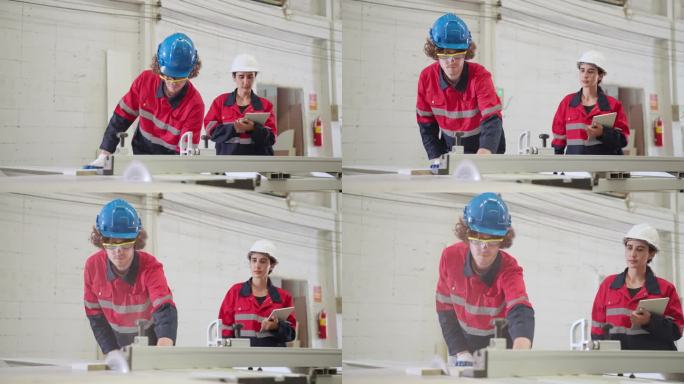 穿着防护服的年轻成年男木匠在胶合板加工切割机前工作，而他的女同事正在用数码平板电脑检查产品的设计和质