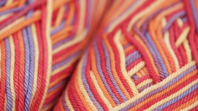 旋转彩色条纹棉纱纱。钩针编织。特写镜头。