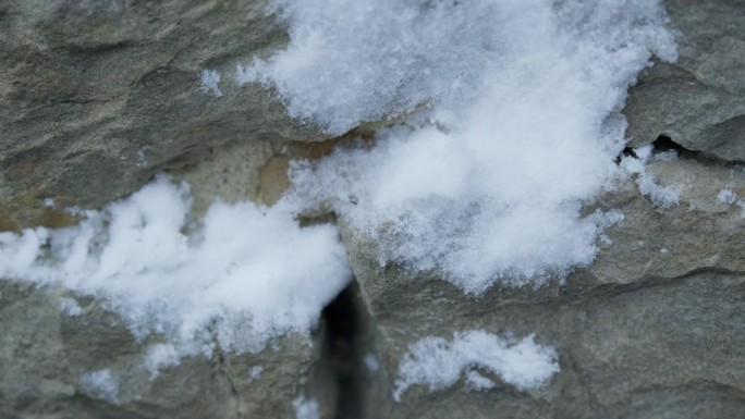 慢动作特写，雪球打在灰色石墙上，溅起水花