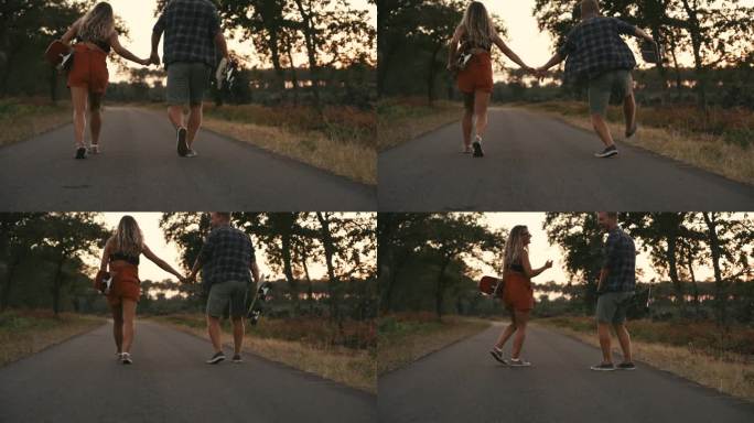 一对夫妇扛着滑板在乡间小路上蹦蹦跳跳的后景
