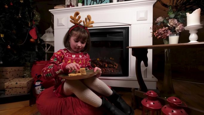 小女孩在壁炉前为新年准备一盘饼干